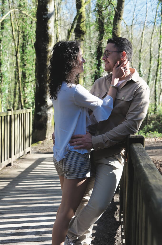 Couple complice sur un pont en bois en forêt, shooting lifestyle à Saint-Hilaire-du-Harcouët.