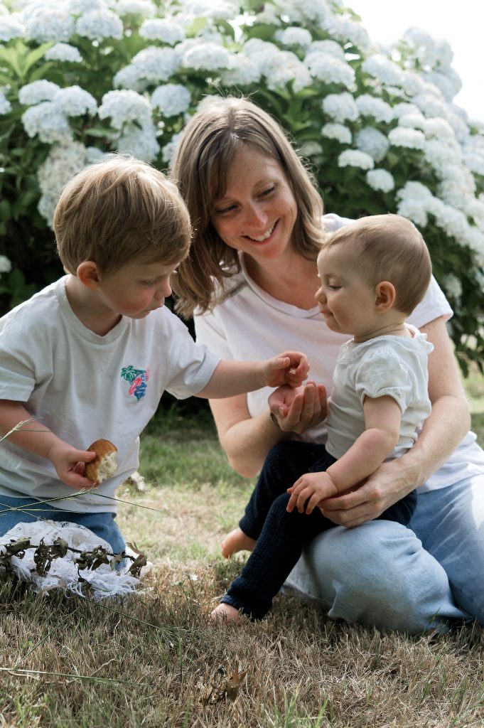 Un moment de complicité spontané lors d'un goûter en famille au jardin. Le bonheur des choses simples.