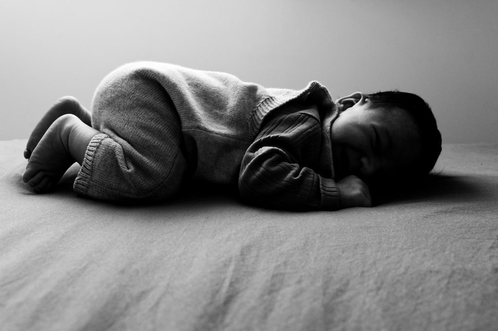 La pureté d'un instant paisible capturée lors d'une séance nouveau-né en noir et blanc.