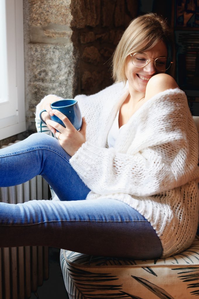 Un instant de douceur et un sourire naturel lors d'une séance photo cocooning à domicile.